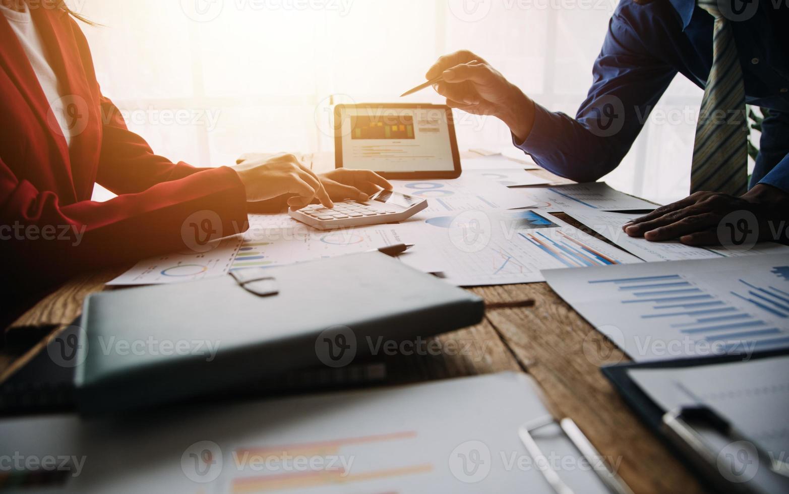 Group of confident business people point to graphs and charts to analyze market data, balance sheet, account, net profit to plan new sales strategies to increase production capacity. photo