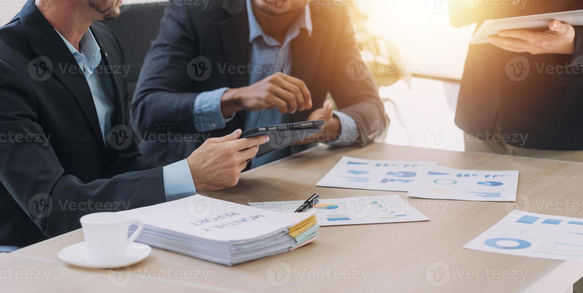 Financial analysts analyze business financial reports on a digital tablet planning investment project during a discussion at a meeting of corporate showing the results of their successful teamwork. photo