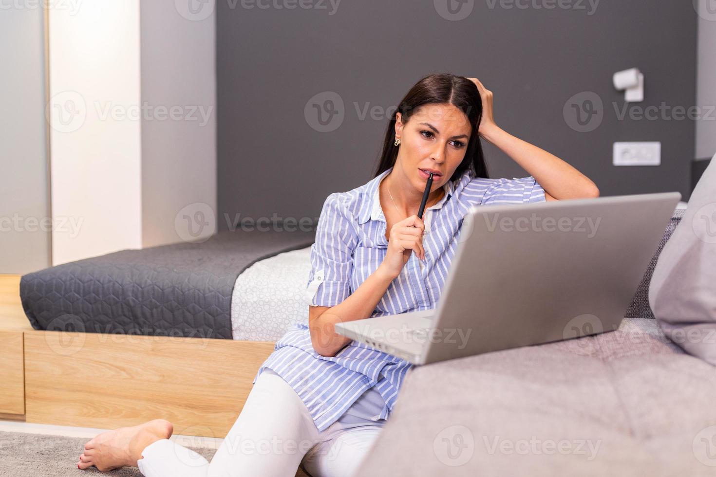 Beautiful business woman freelancer noting information for planning project doing remote job via laptop computer. Woman working from home on modern laptop device . photo