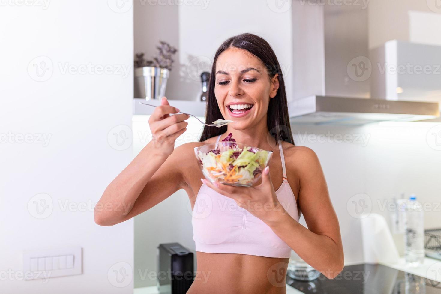 Young caucasian woman eating salad. Healthy Diet. Beautiful Smiling Woman Eating Fresh Organic Vegetarian Salad. Healthy Eating, Food And Lifestyle Concept. Health, Beauty photo