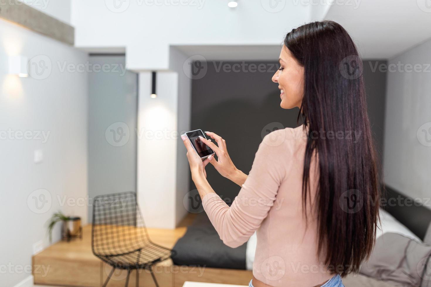 Smart home technology interface on smart controler app screen with augmented reality AR view of internet of things IOT connected objects in the apartment interior, person holding device photo