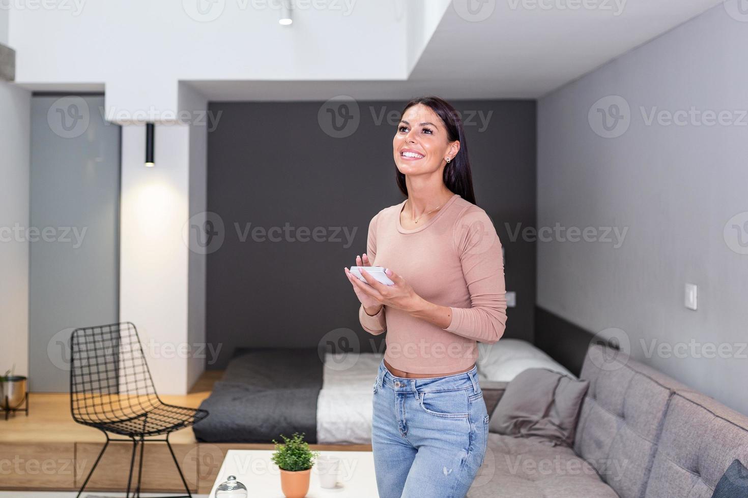 Smart home technology interface on smart controler app screen with augmented reality view of internet of things connected objects in the apartment interior, person holding device photo