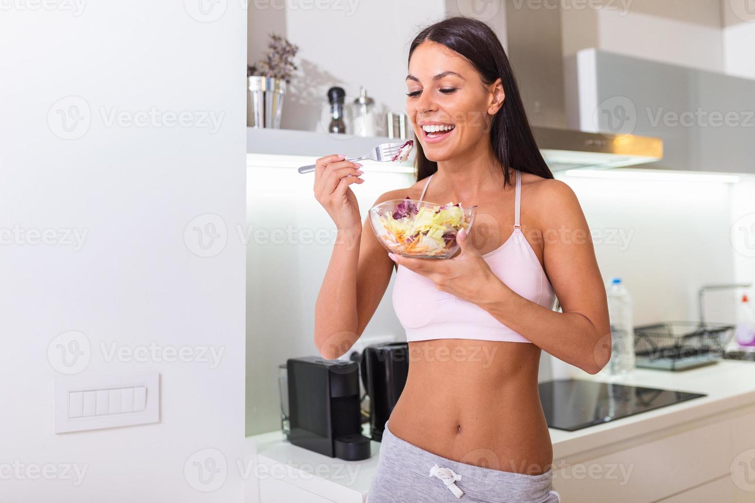 Young caucasian woman eating salad. Healthy Diet. Beautiful Smiling Woman Eating Fresh Organic Vegetarian Salad. Healthy Eating, Food And Lifestyle Concept. Health, Beauty photo