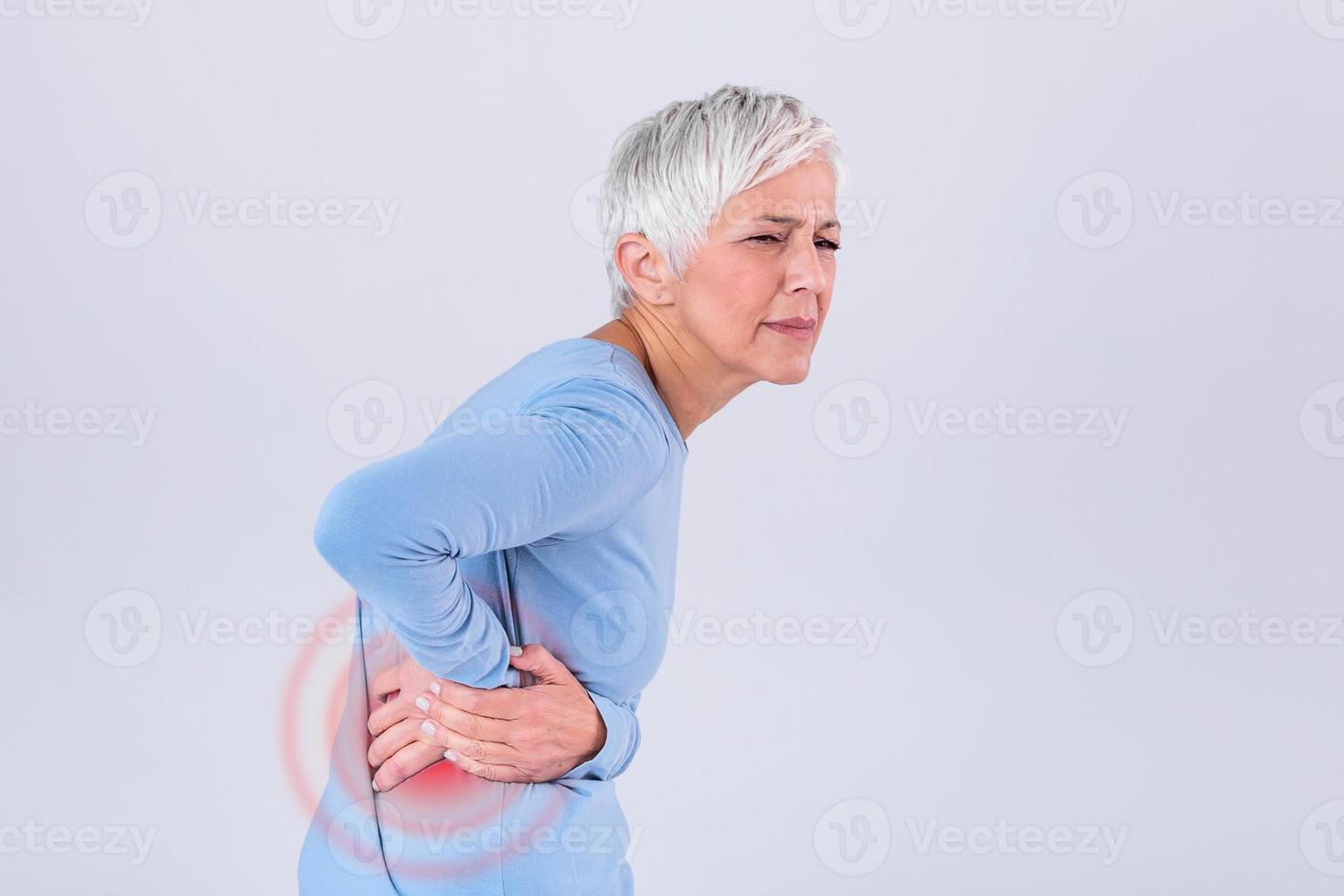 Elderly woman with gray hair touching her aching hip. Upset mature old woman touching back feel hurt osteoarthritis kidney spine ache sore muscles, sad senior lady suffer from lower lumbar pain photo