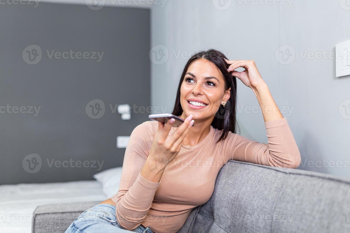 cerca arriba de bonito mujer participación en mano inteligente teléfono hablando con digital asistente o amigo de lejos usos fácil voz mensajería, concepto de moderno ai tecnología, voz reconocimiento, en línea traductor foto