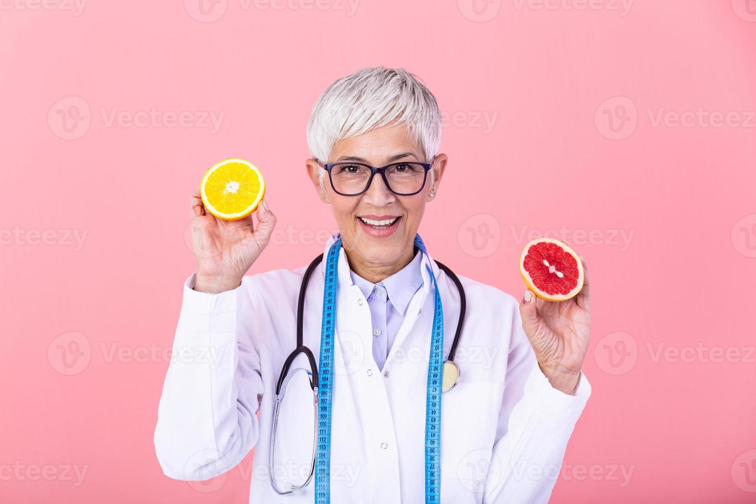 Happy dietitian nutritionist holding grapefruit and orange having fun. Woman promoting healthy food fruit. Right eating nutrition and slimming concept. photo