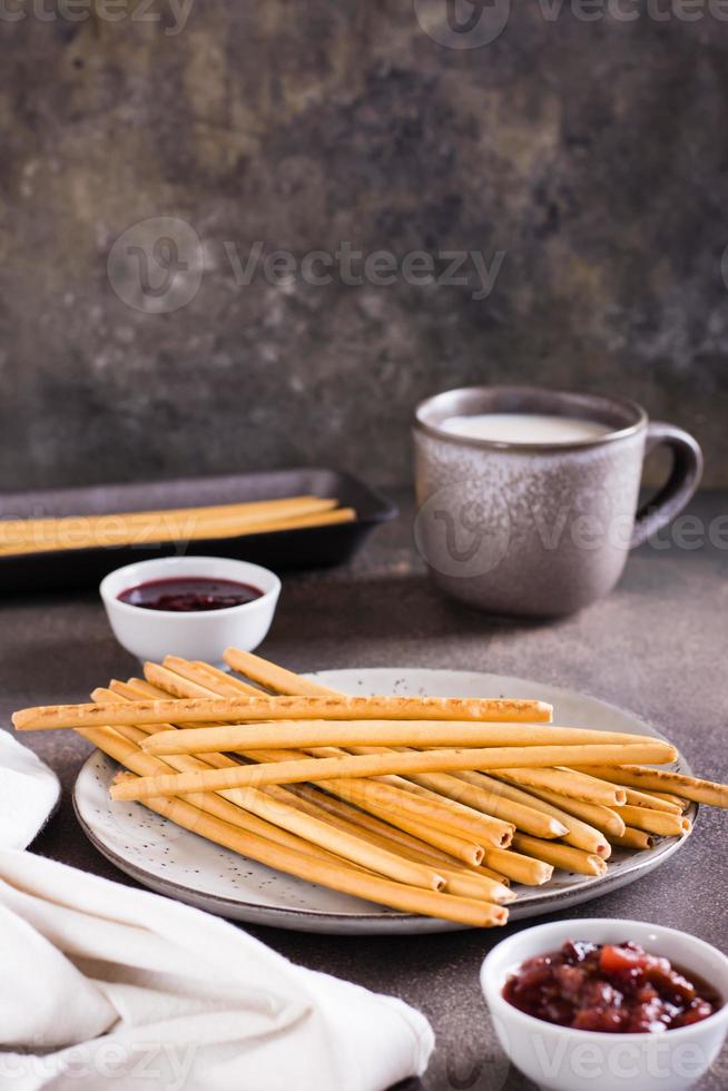 Crispy bakery straws with berry filling on a plate for dessert. Vertical view photo