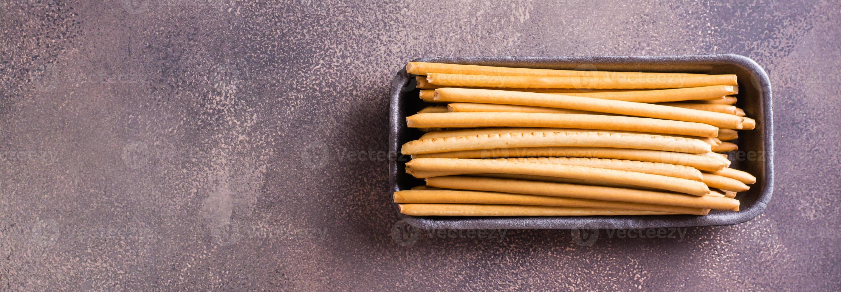 Crispy toasted sweet straws with berry jam in a container. Top view. Web banner photo