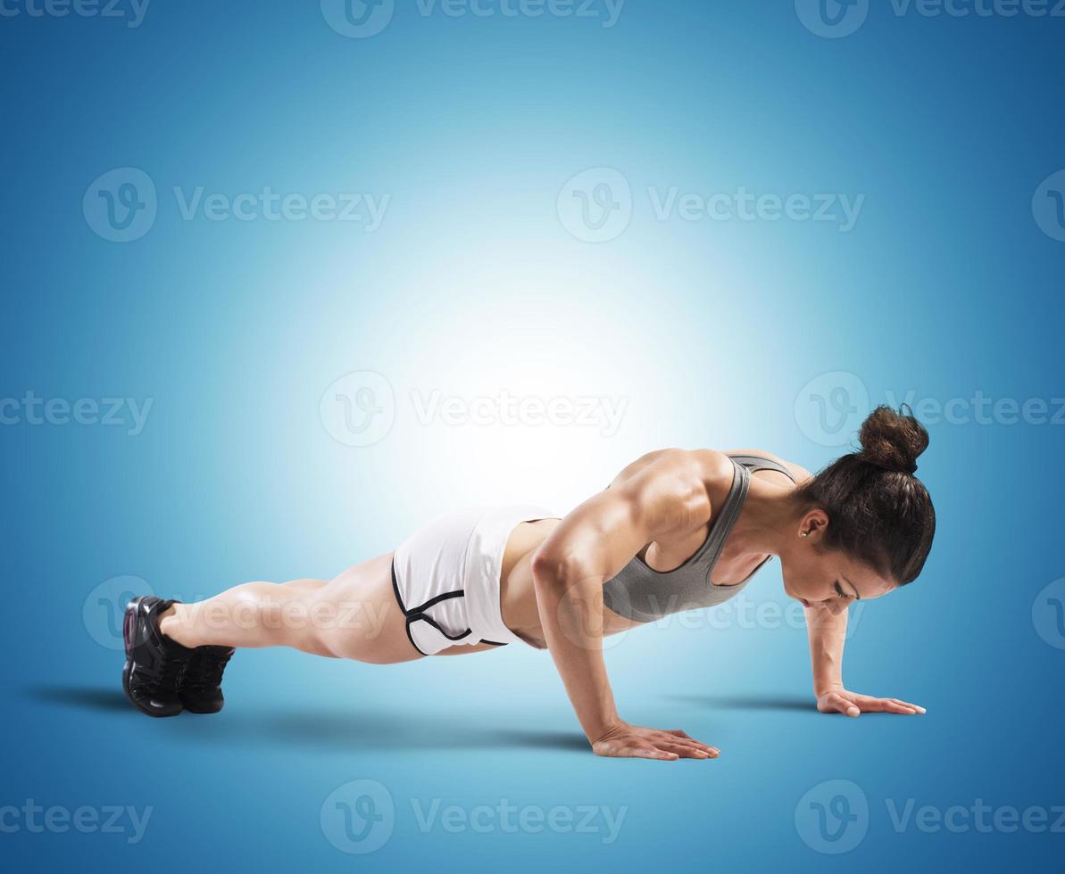 Fitness woman doing push-ups photo