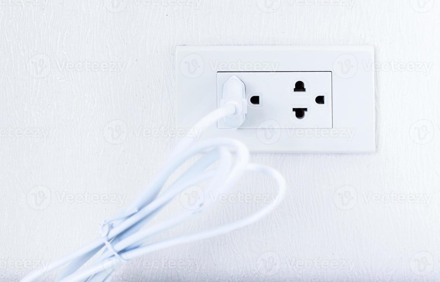 Plug power socket on the white wall photo