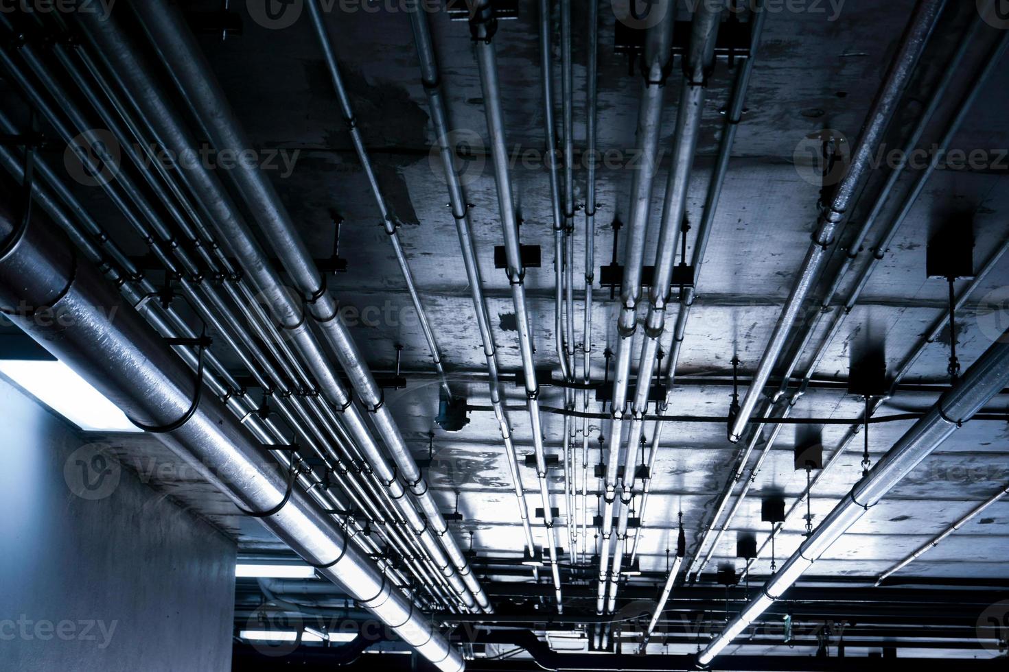 Sanitary system pipes and electrical cables installed under flat slab reinforced concrete structure in building.Ventilation pipes in Underground Parking photo