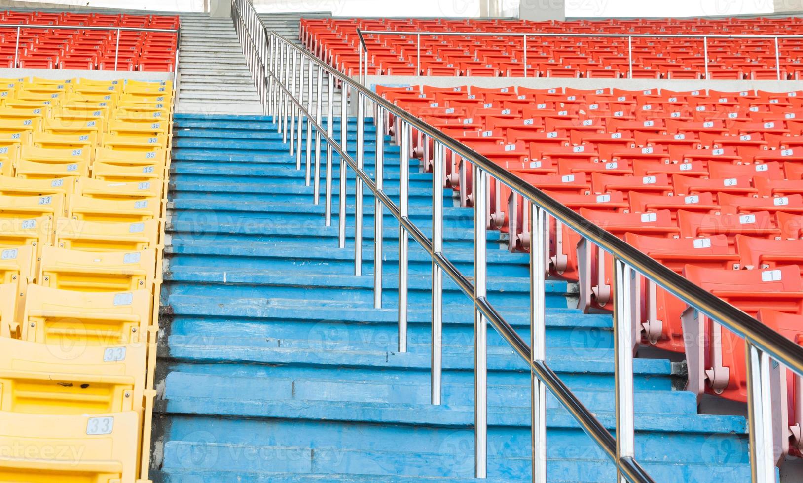 Empty orange and yellow seats at stadium,Rows of seat on a soccer stadium photo