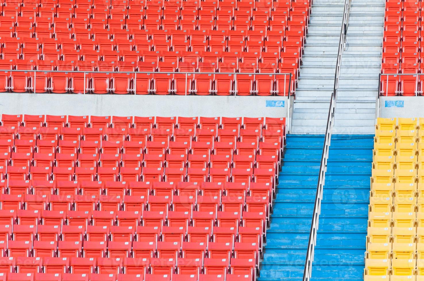 Empty orange and yellow seats at stadium,Rows of seat on a soccer stadium photo