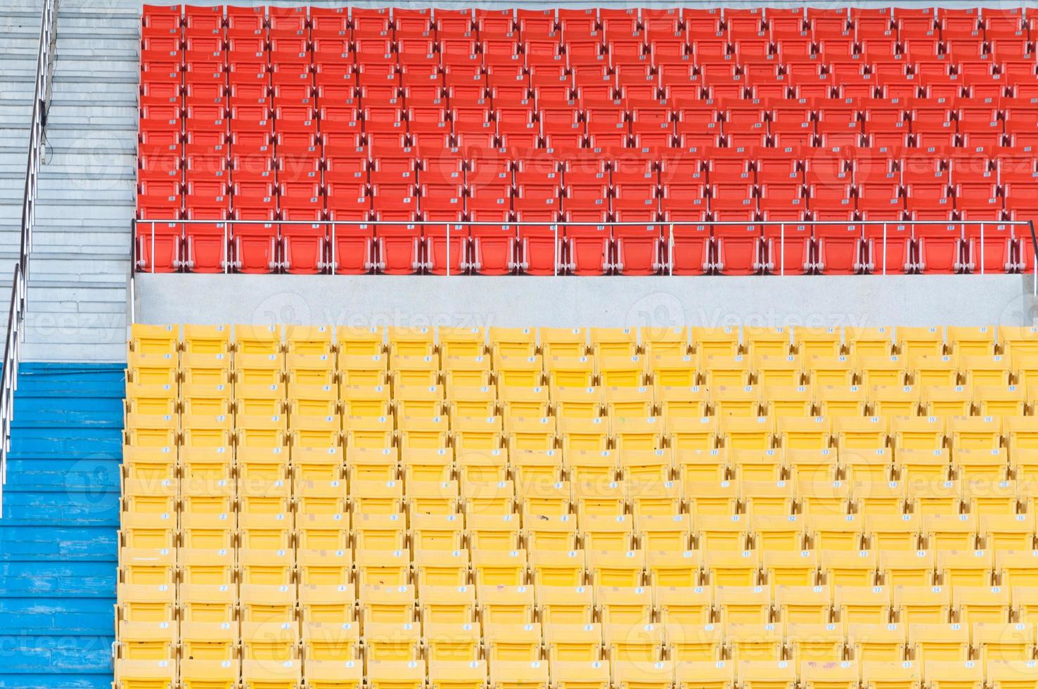 Empty orange and yellow seats at stadium,Rows of seat on a soccer stadium photo