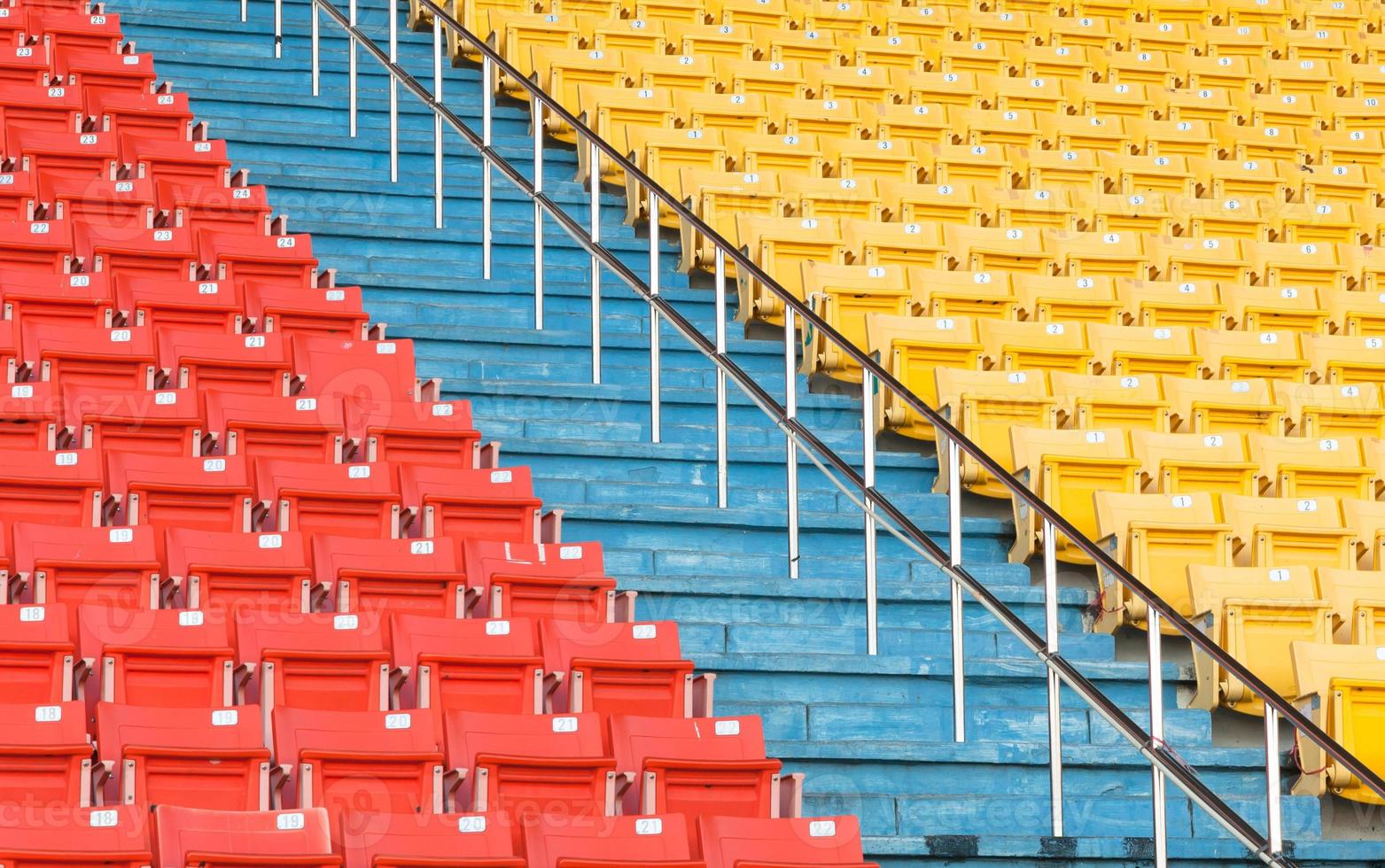 Empty orange and yellow seats at stadium,Rows of seat on a soccer stadium photo