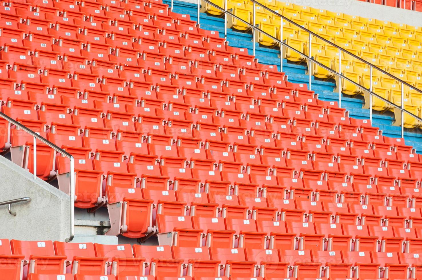 Empty orange and yellow seats at stadium,Rows of seat on a soccer stadium photo