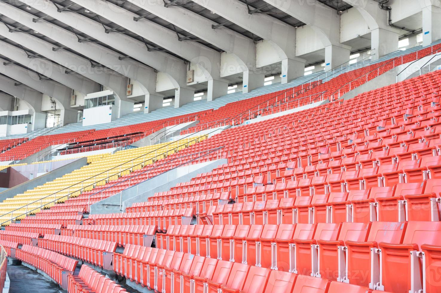 Empty orange and yellow seats at stadium,Rows of seat on a soccer stadium photo