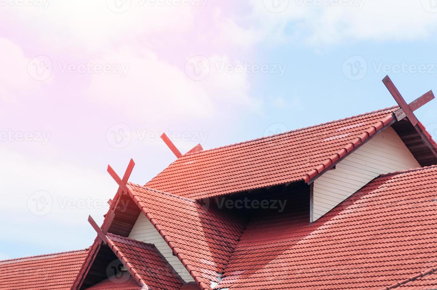 red Roof house with tiled roof on blue sky photo