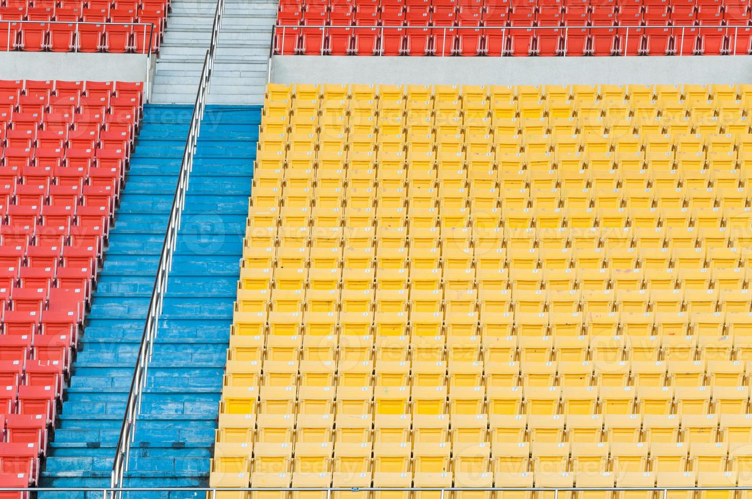 Empty orange and yellow seats at stadium,Rows of seat on a soccer stadium photo