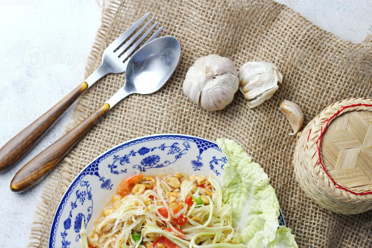 Somtum, Thai spicy papaya salad on white background, international Thai food Known and popular, made with papaya and tomatoes, it tastes sour, sweet and spicy. photo