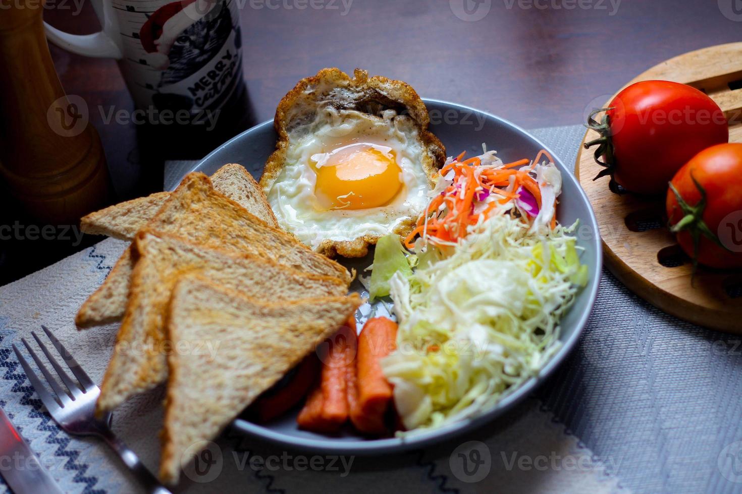 desayuno, frito huevos, frito embutido, vegetal ensalada y brindis en un marrón de madera mesa con café. foto