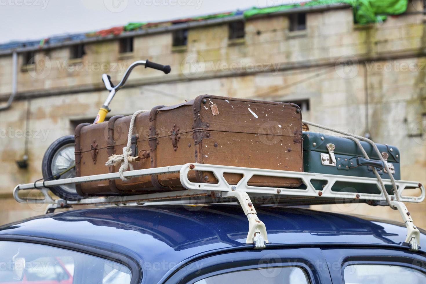 Old luggages atop of a retro car photo