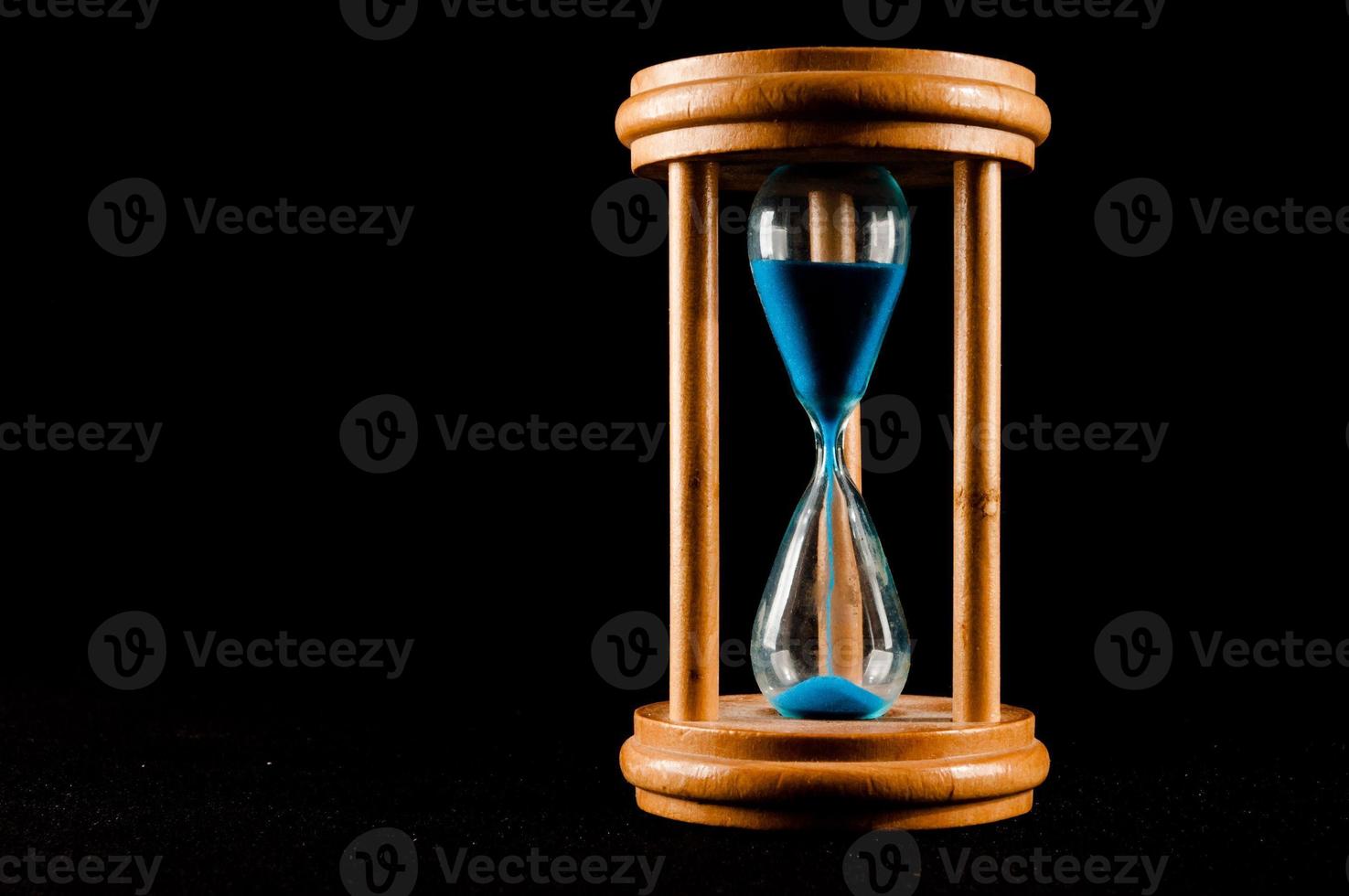 Hourglass on black background photo