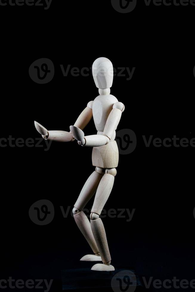 Wooden mannequin on dark background photo