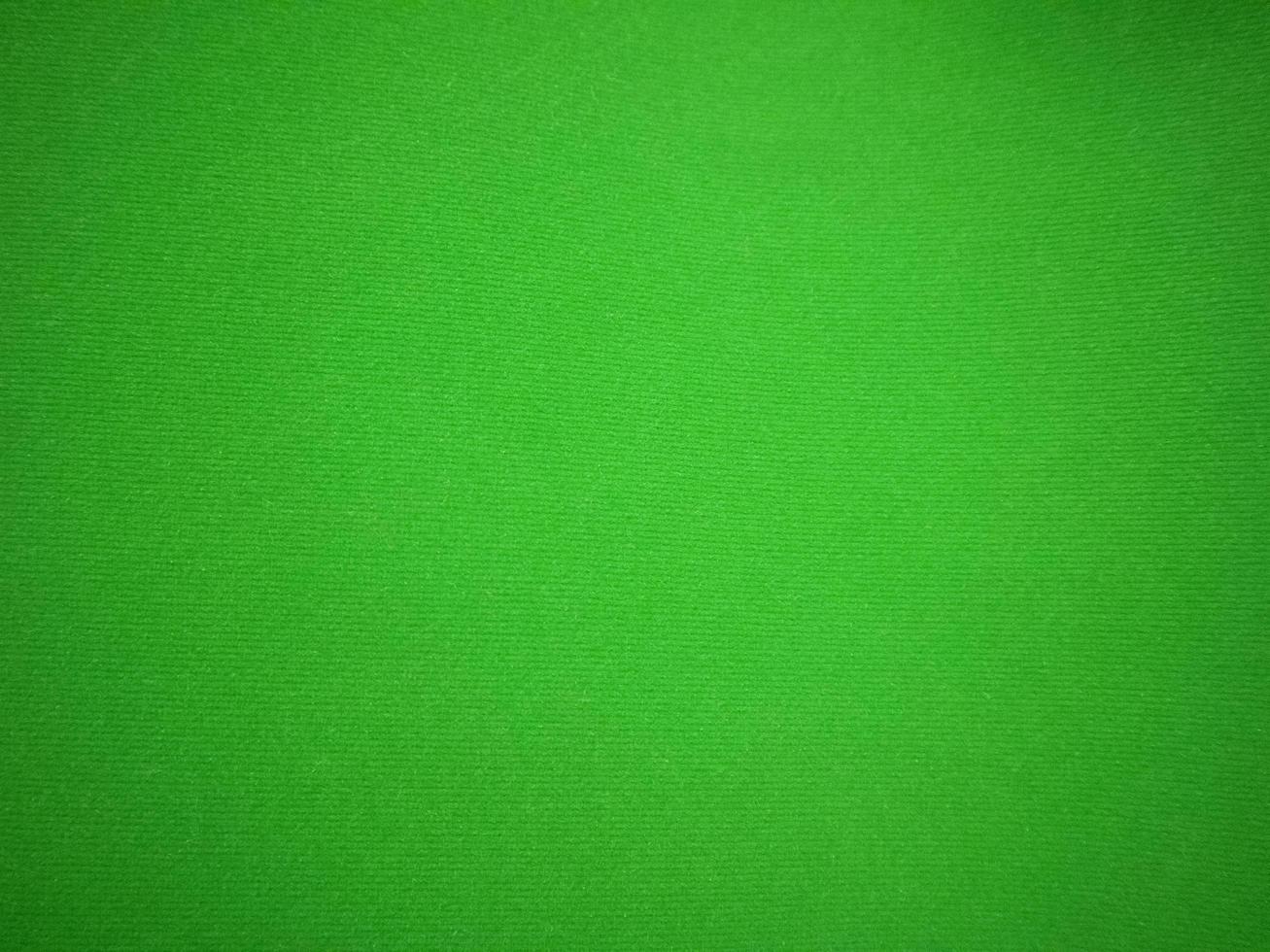 textura de tela de terciopelo verde utilizada como fondo. fondo de tela verde vacío de material textil suave y liso. hay espacio para el texto.. foto