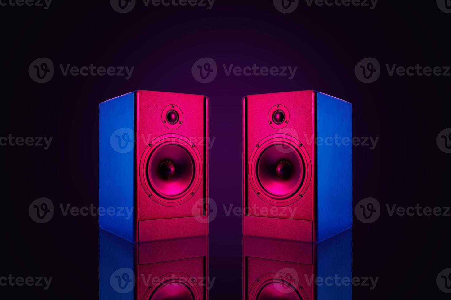 Two stereo speakers with neon light on dark background photo