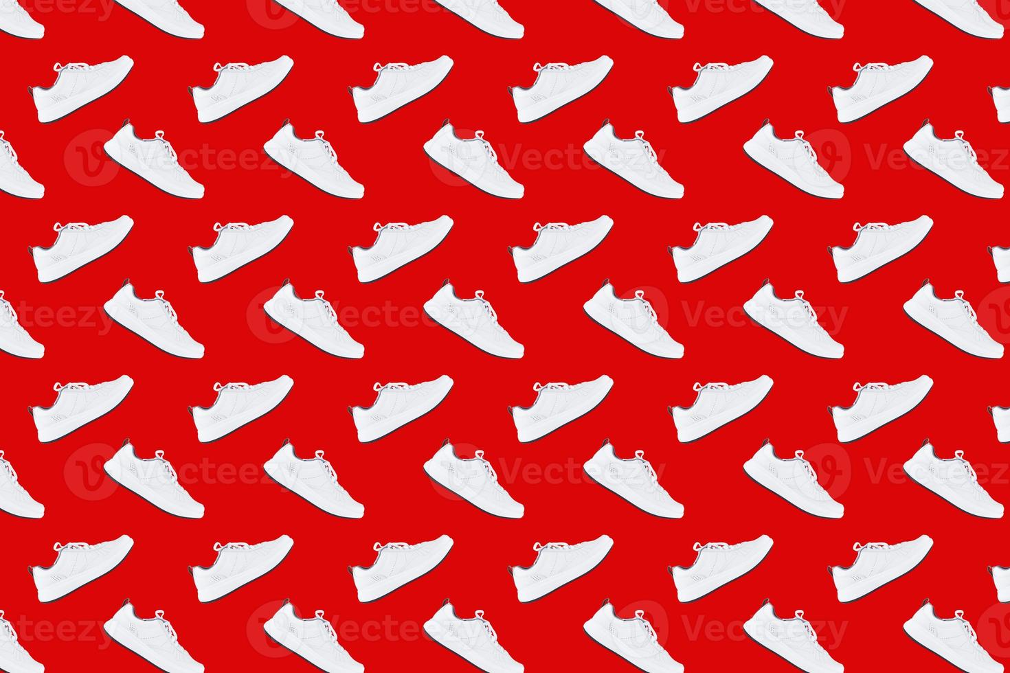 Seamless pattern with white sneakers on red background photo
