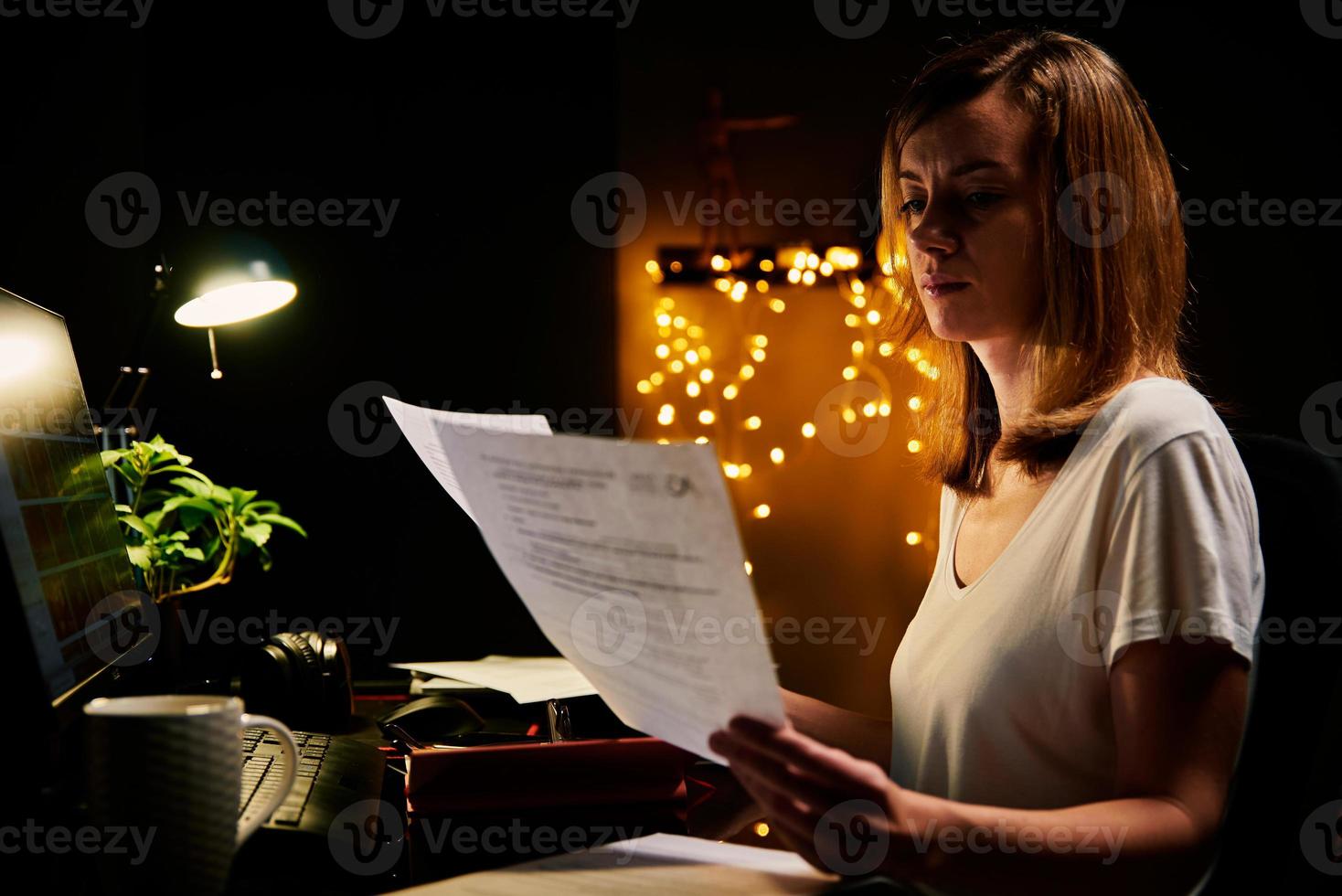 Tired woman works late at home workplace photo