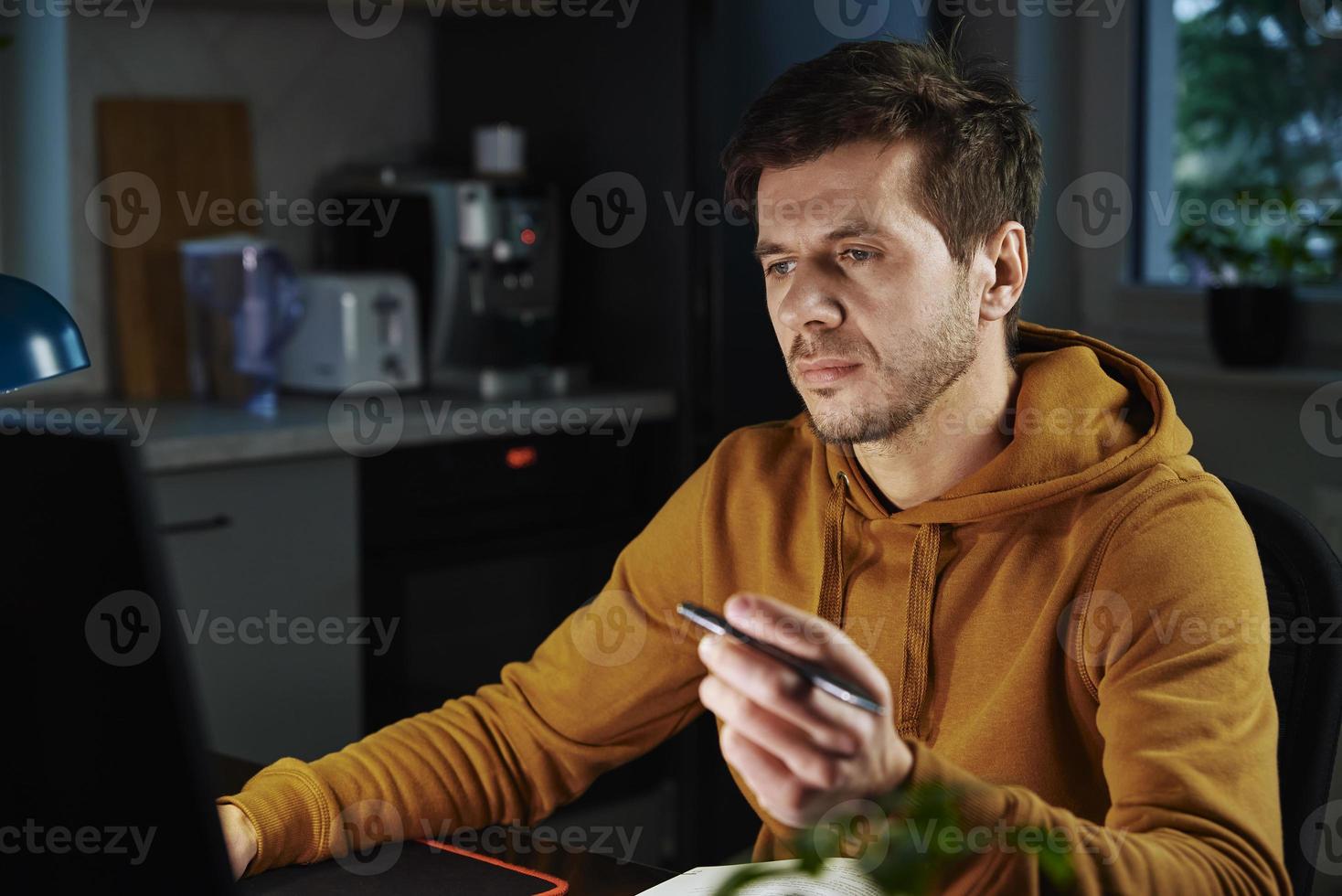 Man works at home office remotely, using computer photo