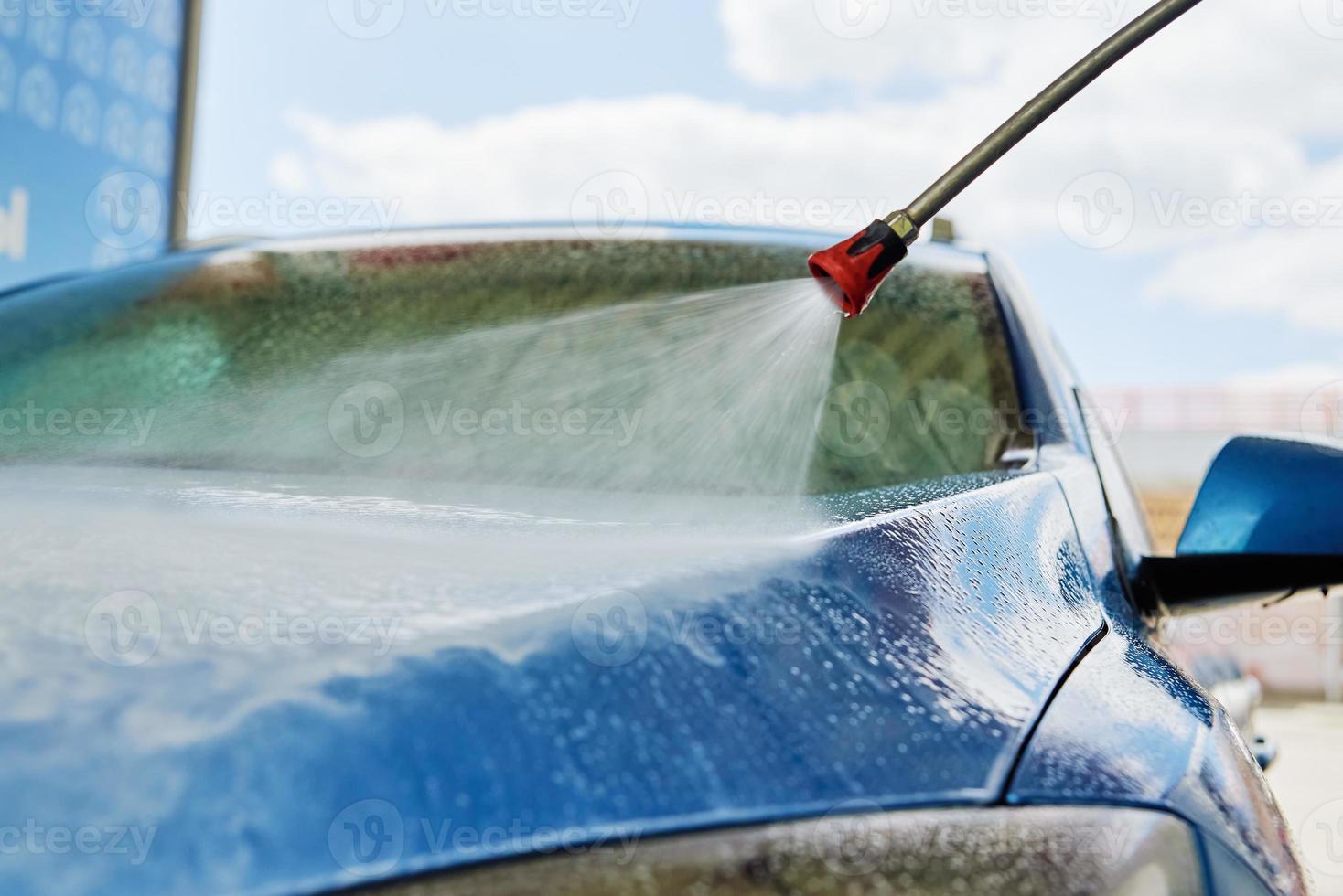 coche de limpieza con agua a alta presión en la estación de lavado de coches foto