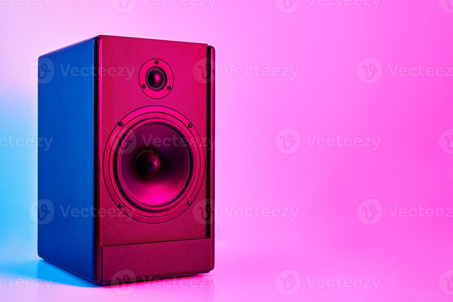 altavoz de sonido estéreo sobre fondo de color neón foto