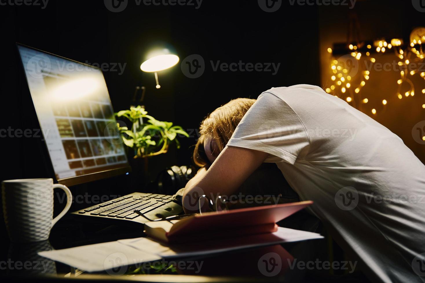 Tired woman works late at home workplace photo