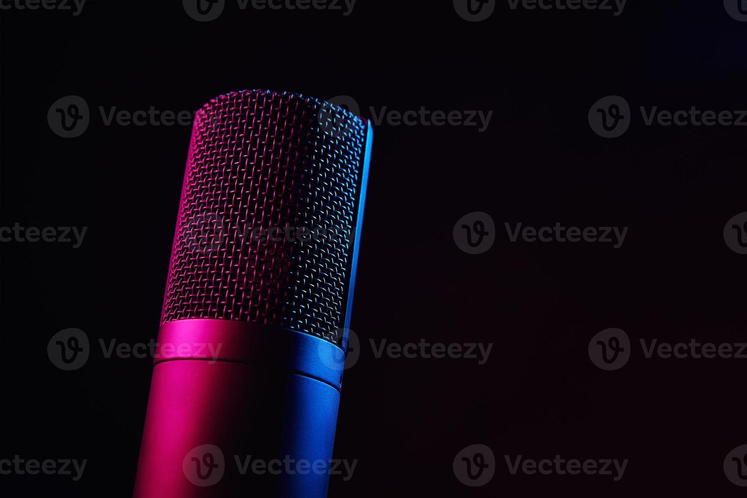 Studio microphone on dark background with neon lights photo