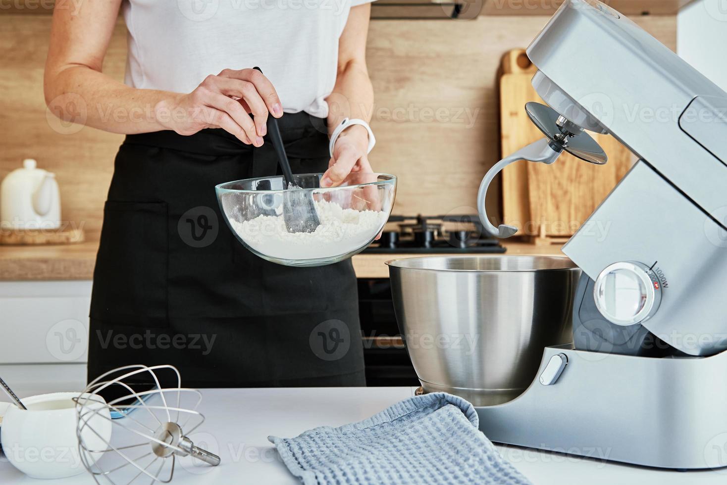 Woman cooking at kitchen and using kitchen machine photo