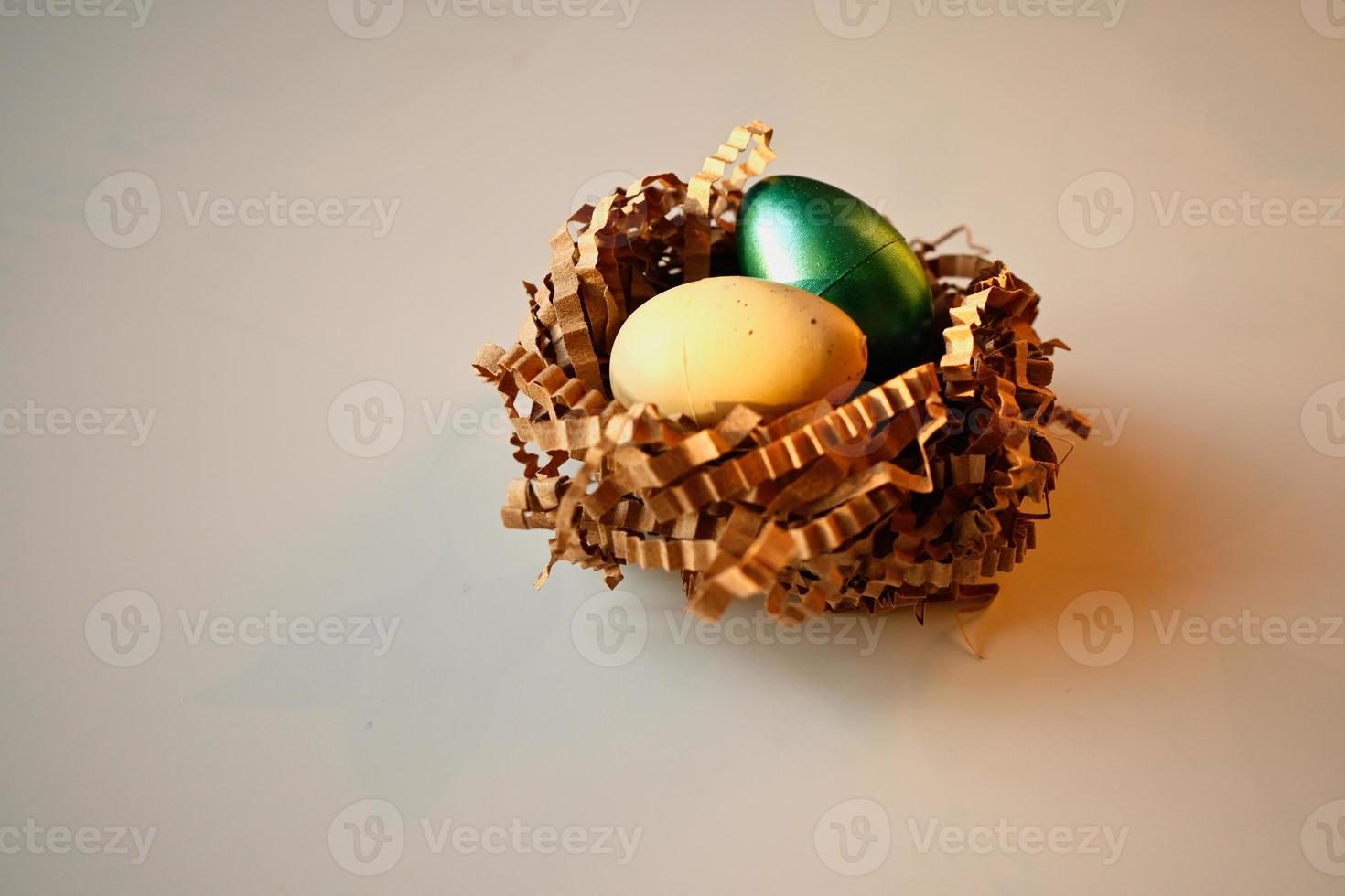Colored Easter eggs, in a beautiful plate. Chocolate Easter eggs in a natural straw nest photo
