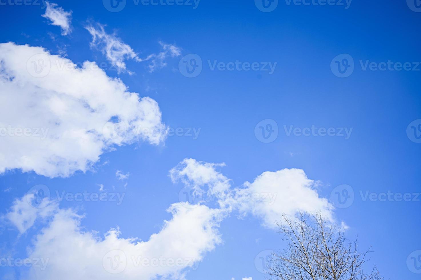 Blue sky with white clouds. Bright sunny day. Cumulus clouds high in the azure sky, beautiful view of the cloudy landscape. photo