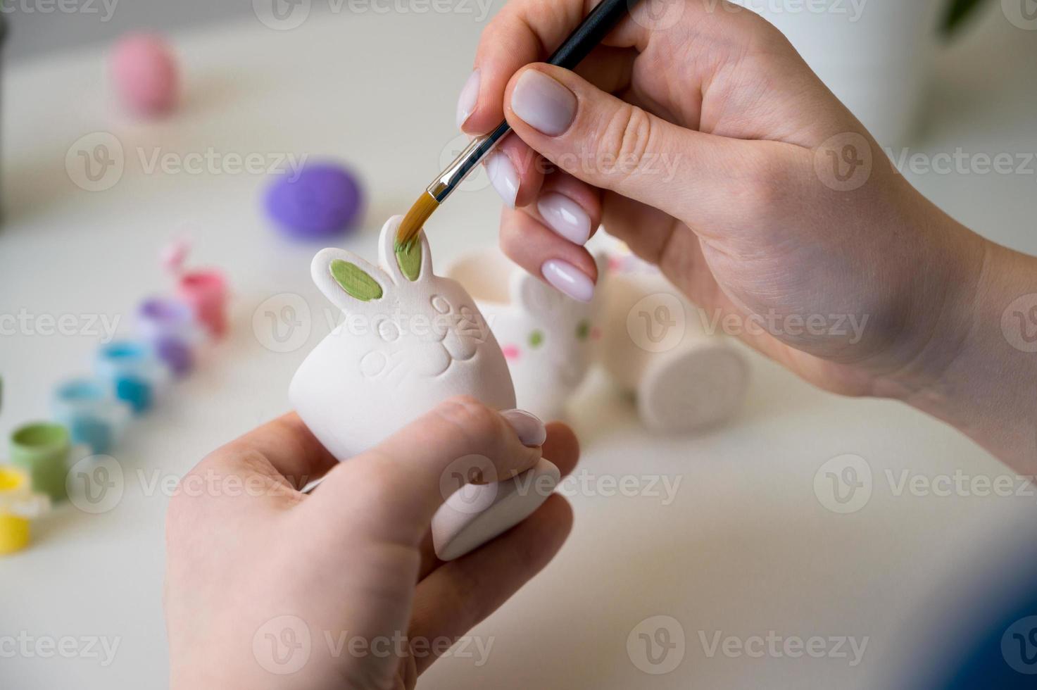 Vase with beautiful flowers, Easter bunny holder with eggs,paints and brush.Vertical banner photo