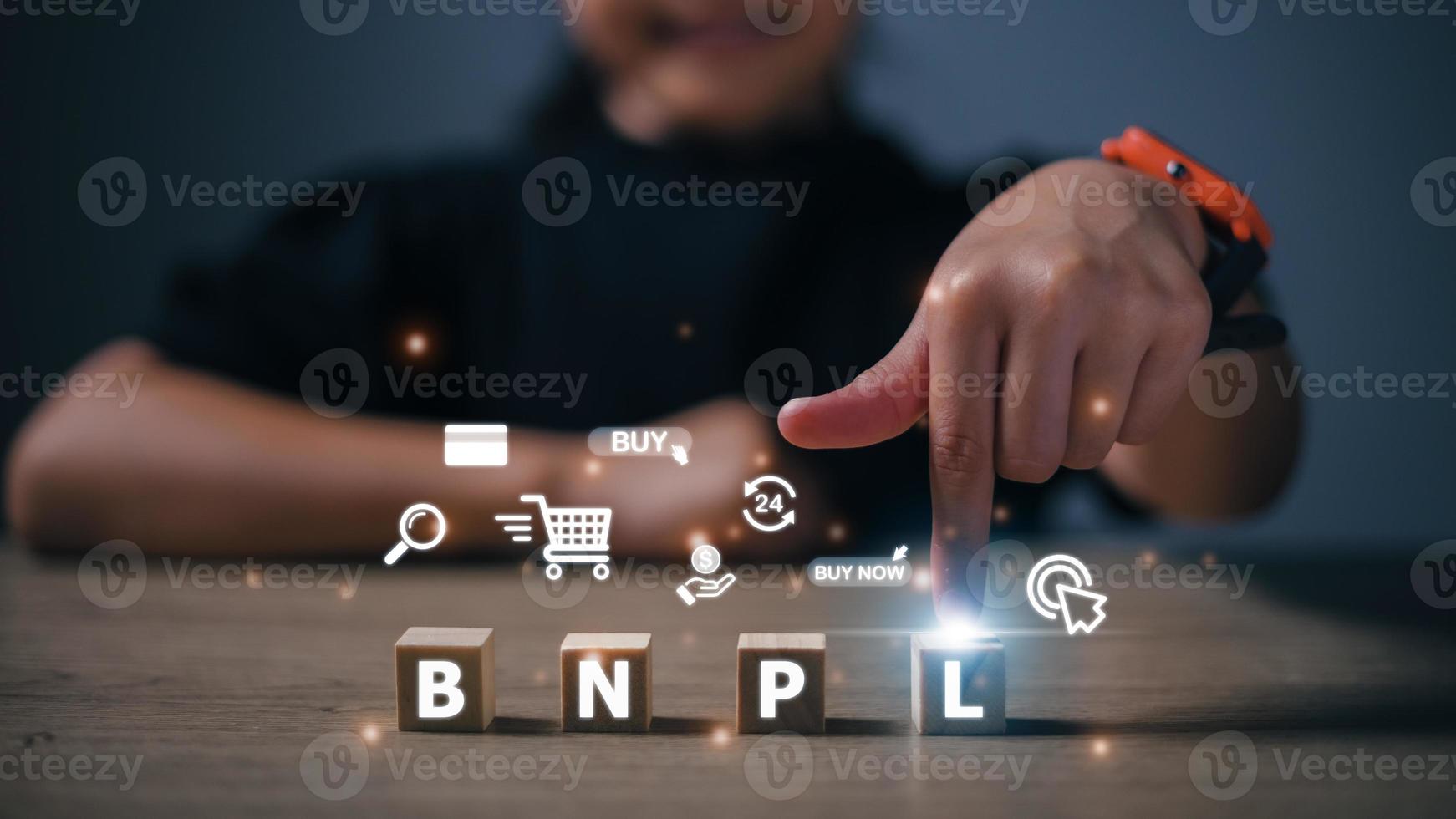 Women press their fingers on the wooden cubes with BNPL with online shopping icons. BNPL Buy now pays later online shopping concept. photo