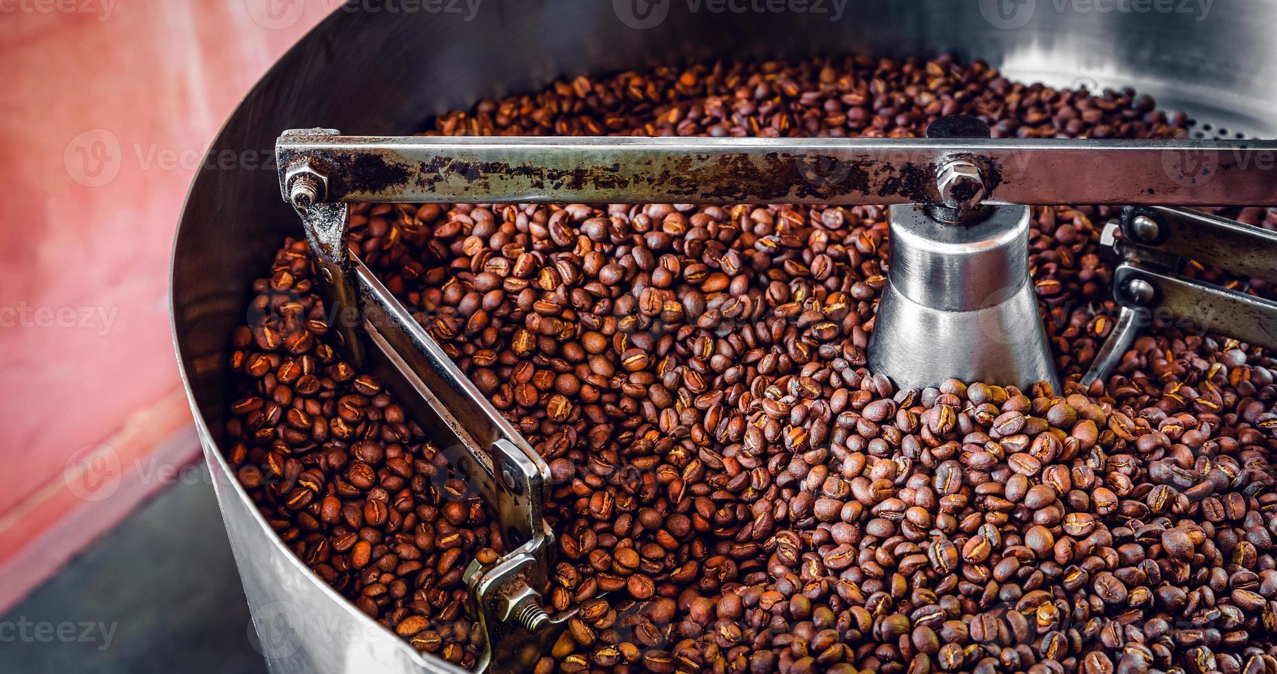 Freshly roasted aromatic coffee beans over a modern coffee roasting machine. photo