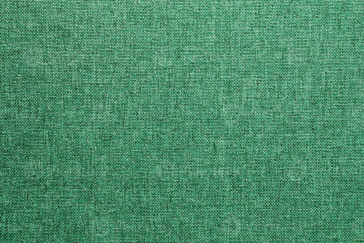Abstract design background of green emerald coarse-grained intersection texture of rough fabric with an interlacing. Linen sack textile canvas burlap cloth. Close-up, mock up, top view photo