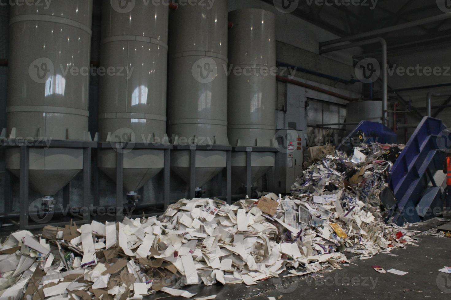 Shredding waste paper conveyor belt for recycling wrap, garbage and cardboard against bales of used carton boxes collected for reuse at industrial plant factory. Zero waste, eco-friendly concept photo