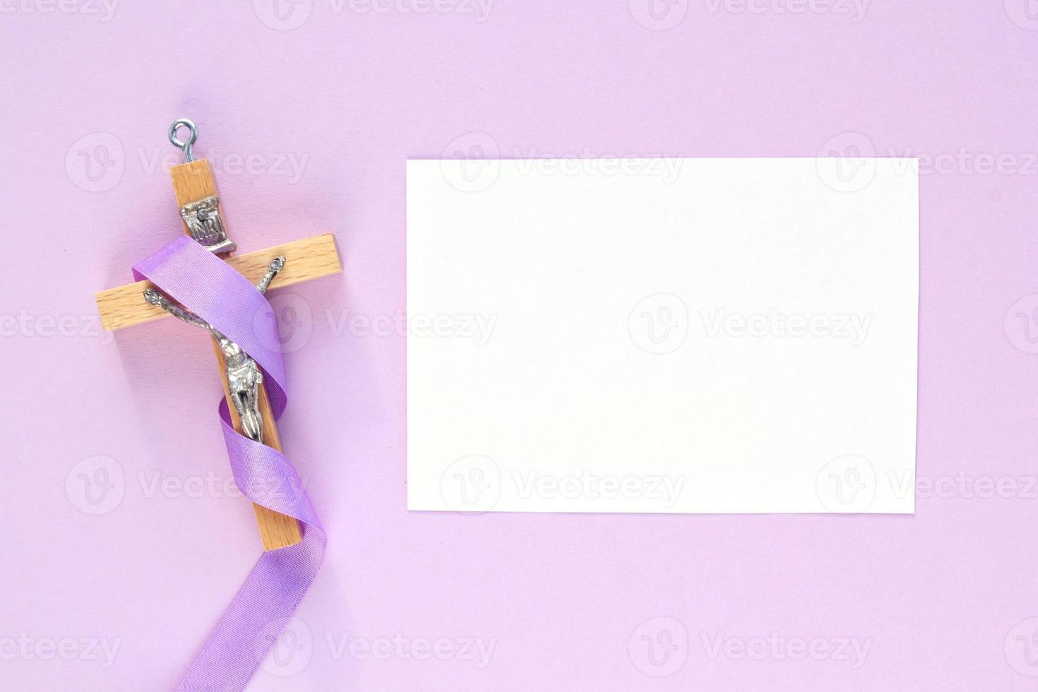 Christian religious wooden cross crucifix with violet ribbon on purple background. Catholic religion symbol. Good Friday, Lent Season, Palm Sunday, Ash Wednesday and Holy Week concept. Copy space photo