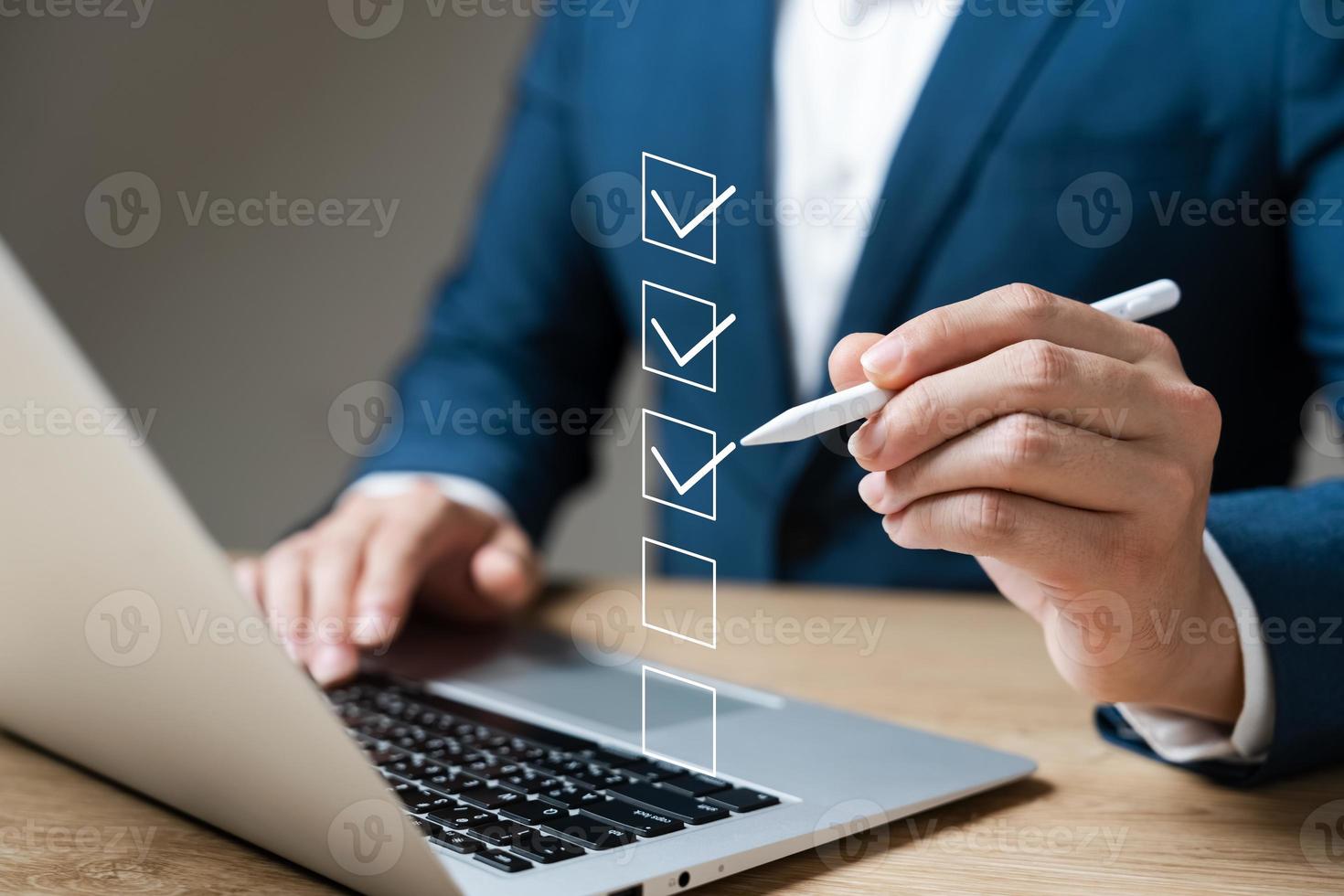 Business performance checklist concept, businessman using laptop doing online checklist survey, filling out digital form checklist. photo