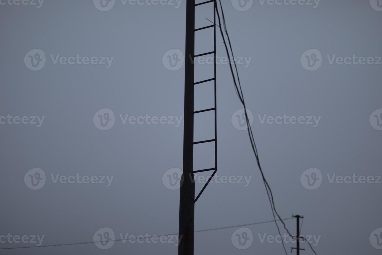 Wires on pole. Electrical wires on background of gray sky. Depressing look. photo