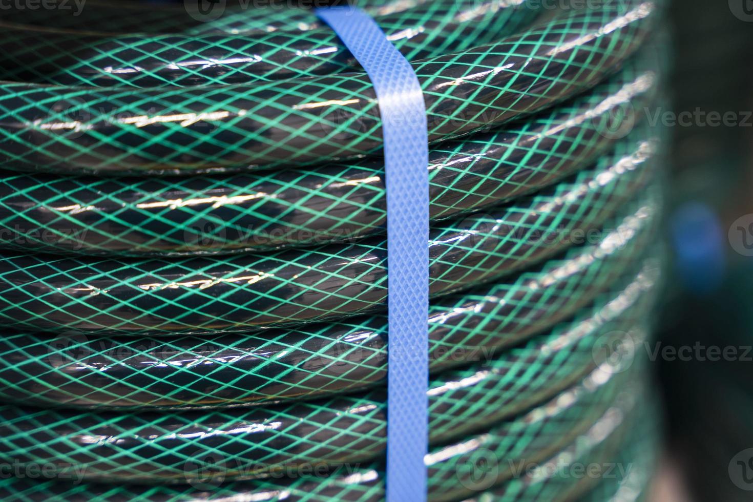 New green garden watering hose wound into a bay photo