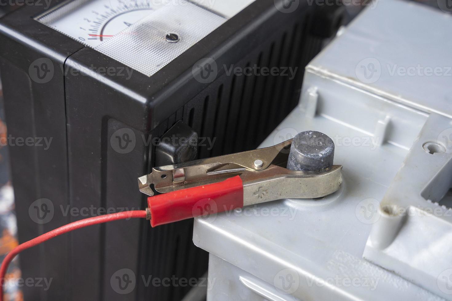 The process of charging the car accumulator, the terminal of the 12V car battery and the charger photo
